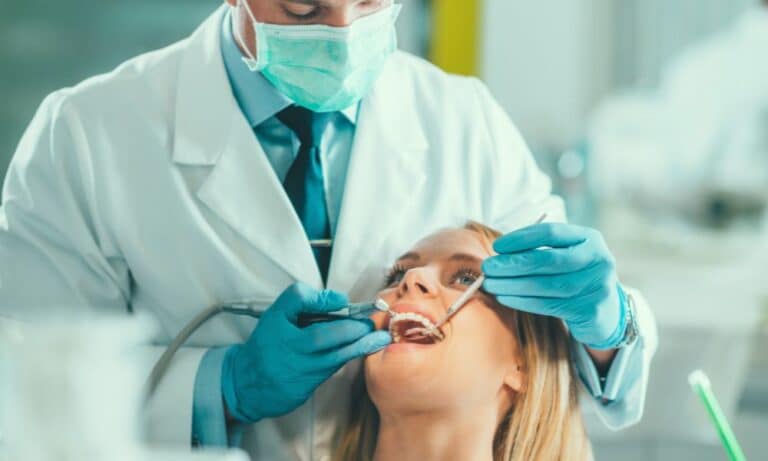 A dentist performing a procedure on a patient in a dental clinic, illustrating various payment options for cosmetic dentistry treatments.